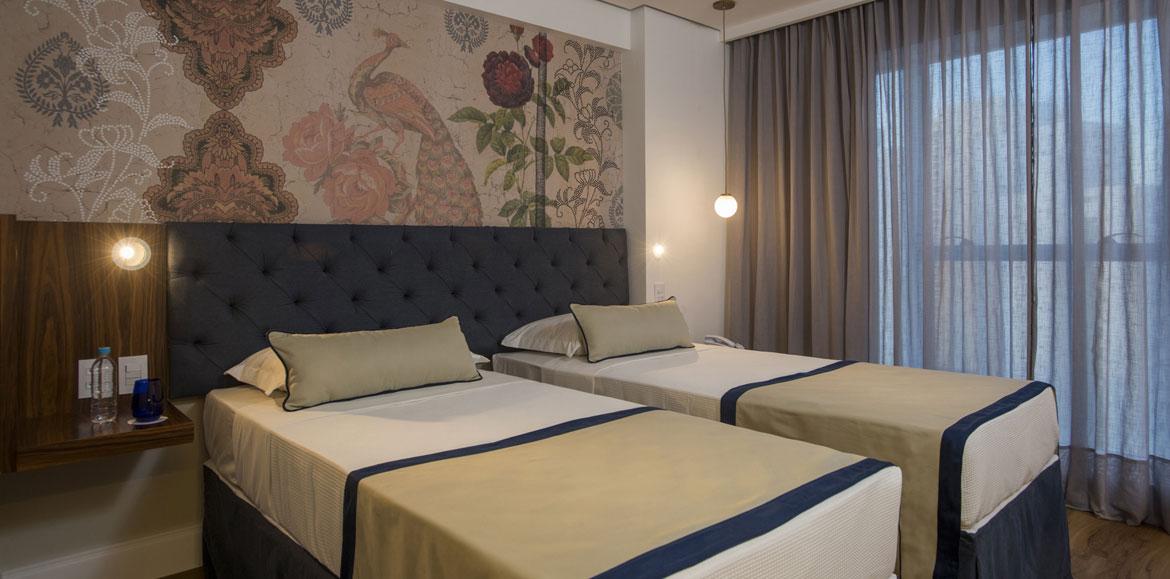 Hotel Luzeiros Recife Dış mekan fotoğraf The photo shows a modern bedroom featuring two single beds that are neatly made with light-colored blankets and decorative pillows. The headboard of the beds is upholstered in a dark material, giving it a stylish appearance. Behind the beds, there is